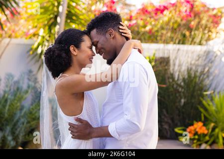 Heureux couple afro-américain se mariant, embrassant pendant le jour du mariage Banque D'Images