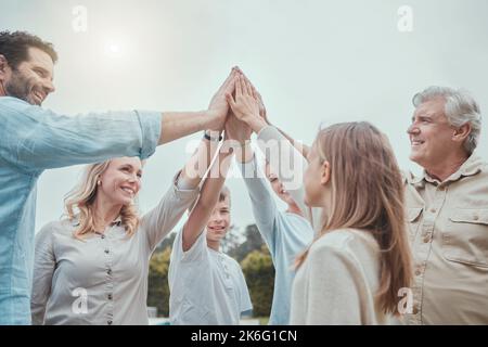 Nous nous soutenons les uns les autres jusqu'à la fin une famille se donnant un cinq haut dans le jardin à la maison. Banque D'Images