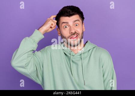 Gros plan photo de jeune drôle nerveux stressé homme gratter sa tête ne sais pas ce qui ne se rappelle pas hier isolé sur fond violet de couleur Banque D'Images