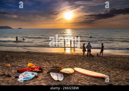 Vacanciers profitant d'un coucher de soleil spectaculaire sur la baie de Fistral à Newquay en Cornouailles au Royaume-Uni en Europe. Banque D'Images