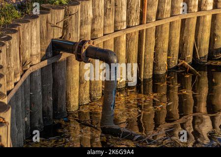 tuyau de la pompe immergée dans un étang. prise d'eau Banque D'Images