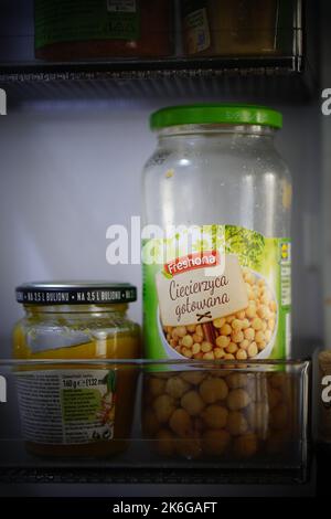 Un gros plan vertical des pois chiches de la marque Freshona dans un pot en verre à l'intérieur d'un réfrigérateur Banque D'Images