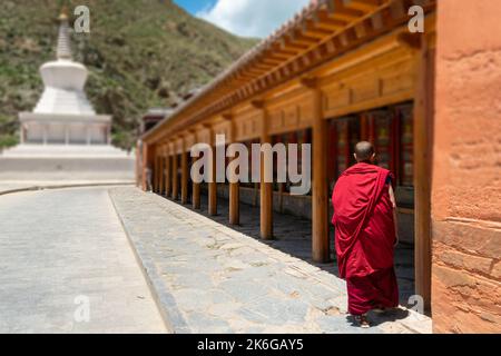 Moine bouddhiste avec roues de prière au Temple Labrang, Xiahe, Gannan, Gansu, Chine Banque D'Images