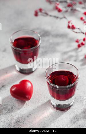 Cocktail rouge, vodka ou liqueur et décorations en forme de coeur Banque D'Images