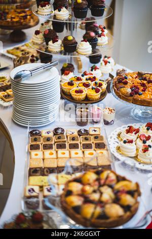 Délicieux réception de mariage bar de bonbons table de dessert avec divers bonbons, petits gâteaux, fruits et tartes. Banque D'Images