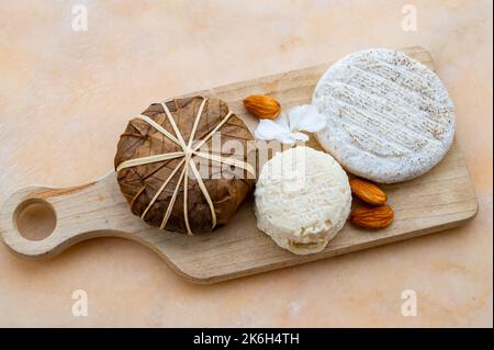 Dégustation de France, petit fromage rond Tome de Provence, petit fromage de chèvre mûr et fromage de montagne banon enveloppé de feuilles de châtaignier, Alpes-de-haute- Banque D'Images