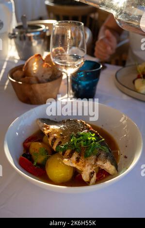 Cuisine provençale, filet grillé de poisson blanc au seabass servi avec des pommes de terre, des tomates et du jus de poisson Bouillabaisse dans le restaurant français Banque D'Images