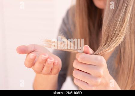 Vue rapprochée d'une femme méconnaissable qui porte ses cheveux abîmez avec des extrémités fendues et une mise au point sélective Banque D'Images