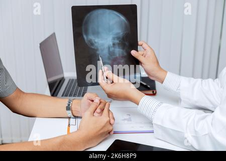 Concept médical et de soins de santé. Médecin expliquant les résultats de radiographie au patient lorsqu'il est assis à la table du bureau. Banque D'Images