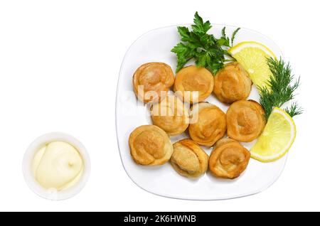 Raviolis frits avec mayonnaise, herbes et citron sur une assiette blanche. Vue de dessus Banque D'Images