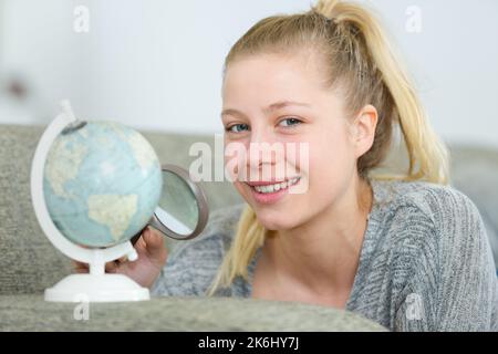 femme tenant une loupe sur la carte du monde Banque D'Images