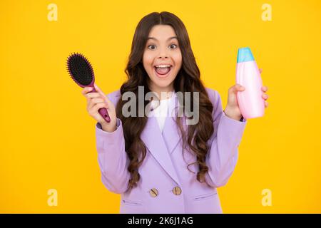 Enfant avec après shampooing. Soins cosmétiques quotidiens. L'adolescent tient un flacon de soins pour les cheveux et la peau. Beauté santé et cosmétiques. Adolescente excitée Banque D'Images