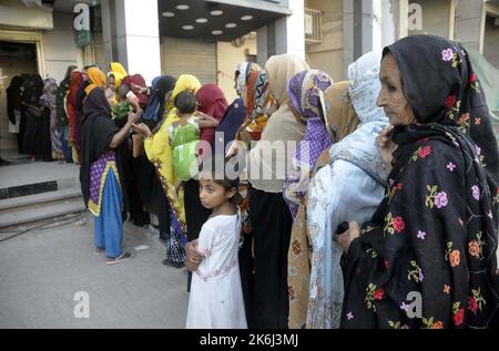 Un grand nombre de femmes pauvres bénéficiaires du Programme de soutien du revenu Benazir Bhutto (BISP) se réunissent à leur tour pour obtenir de l'argent dans une banque située sur la route Autobahn à Hyderabad vendredi, 14 octobre 2022. Banque D'Images