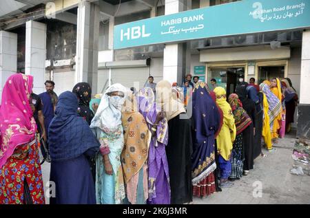 Un grand nombre de femmes pauvres bénéficiaires du Programme de soutien du revenu Benazir Bhutto (BISP) se réunissent à leur tour pour obtenir de l'argent dans une banque située sur la route Autobahn à Hyderabad vendredi, 14 octobre 2022. Banque D'Images