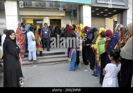 Un grand nombre de femmes pauvres bénéficiaires du Programme de soutien du revenu Benazir Bhutto (BISP) se réunissent à leur tour pour obtenir de l'argent dans une banque située sur la route Autobahn à Hyderabad vendredi, 14 octobre 2022. Banque D'Images