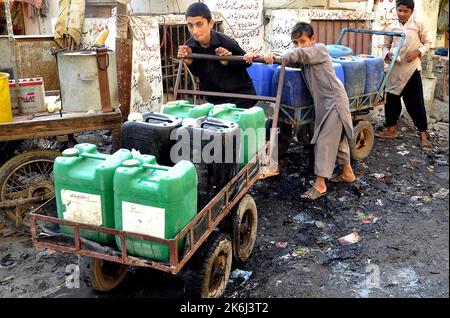 Les citoyens remplissent leurs bidons d'eau du robinet public alors qu'ils sont confrontés à une pénurie d'eau potable dans leur région, dans la région de Sohrab Goth, à Karachi, vendredi, 14 octobre 2022. Banque D'Images