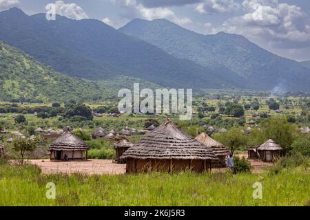 De belles maisons de boue de chaume d'herbe se trouvent dans une vallée au-dessous des collines et des montagnes du district d'Abim, Ouganda, Afrique de l'est. Banque D'Images