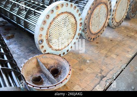 Corrosion, échangeurs de chaleur de raffinerie tubes de refroidisseur avec système à bride. Rangée d'échangeurs de chaleur industriels ou de chaudière avec couvercles de la feuille ou du tube rouillé Banque D'Images