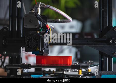 Imprimante électronique en plastique tridimensionnel pendant le travail , 3D imprimantes imprime le modèle rouge, 3D impression Banque D'Images
