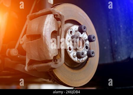 Système de disque de frein sans roue sur une chandelle en attente de réparation dans les ateliers de réparation automobile. Banque D'Images