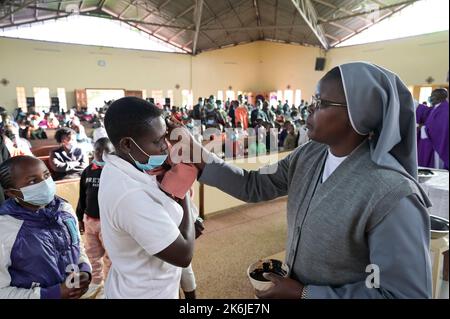 KENYA, Eldoret, Église catholique, mercredi des cendres, début de la saison prêtée, jour Saint de prière et de jeûne, marquant une croix de cendres sur le front / KENIA, Eldoret, Katholische Kirche, Gottesdienst zum Aschermittwoch, Beginn der Fastenzeit vor Ostern, Markierung eines Asche Kreuz auf der Stirn Banque D'Images