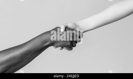 Femme et femme africaine main. Aide à la main, sauvetage, personnes multiathniques. Mains d'aide, geste de secours. Noir et blanc Banque D'Images