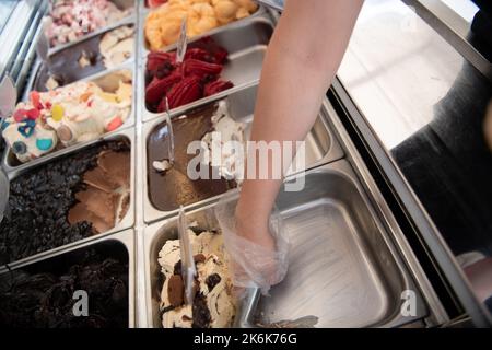 Femme servant de la crème glacée à la confiserie Banque D'Images