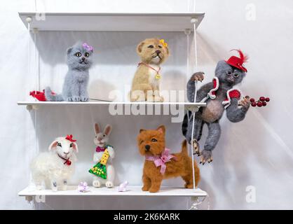 Jouets en feutre sur une étagère blanche dans une chambre pour enfants. Animaux de jeu en laine. Banque D'Images