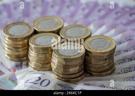 Billets britanniques de vingt livres et pièces de une livre Banque D'Images
