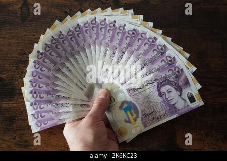 Homme tenant des billets britanniques de vingt livres Banque D'Images