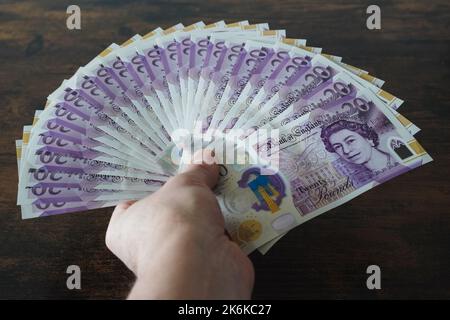 Homme tenant des billets britanniques de vingt livres Banque D'Images
