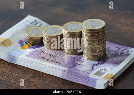 Billets britanniques de vingt livres et pièces de une livre Banque D'Images
