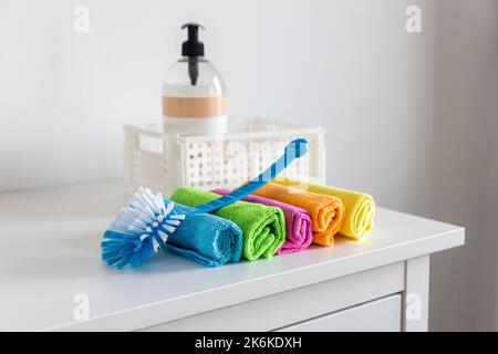 Chiffons en fibres multicolores pour l'époussetage et une brosse en plastique Banque D'Images