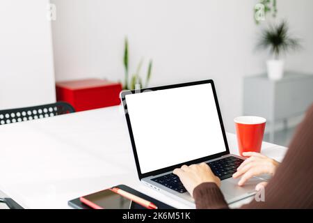 Jeune femme utilisant un ordinateur portable avec un écran blanc maquette au bureau à domicile Banque D'Images