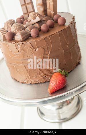 pâtisserie et desserts avec beaucoup de sucre, gâteau fait maison décoré avec du chocolat et une fraise sur l'assiette, gourmandise en studio Banque D'Images