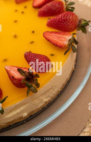 gâteau recouvert de gelée aux fruits de la passion décorés de fraises, sucreries de style gastronomique, gourmandises appétissantes en studio Banque D'Images