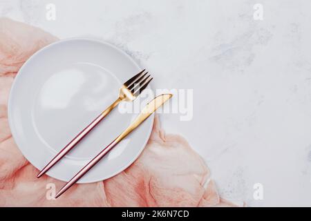 Assiette blanche vide et couverts modernes et élégants sur la table en marbre blanc, vue du dessus Banque D'Images