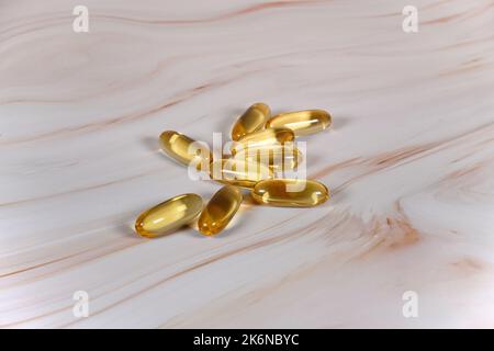 Capsules d'huile de poisson sur comptoir en marbre. Banque D'Images