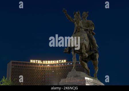 TACHKENT, OUZBÉKISTAN - 15 SEPTEMBRE 2022 : monument à l'Amir Temur (Tamerlane) en toile de fond de l'Hôtel Ouzbékistan en fin de soirée Banque D'Images