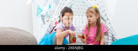 deux petites filles mangeant des fraises Banque D'Images