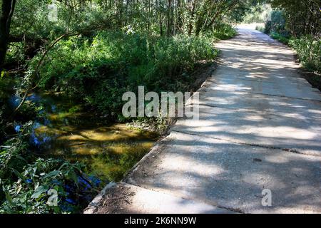 Pont automobile en dalles de béton sur une petite rivière. Rivière Dyrochnaya, district de Zhukovsky, région de Kaluga, Russie Banque D'Images