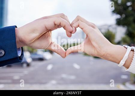 Laissez l'amour briller. un couple méconnaissable faisant un geste de coeur avec leurs mains à l'extérieur. Banque D'Images