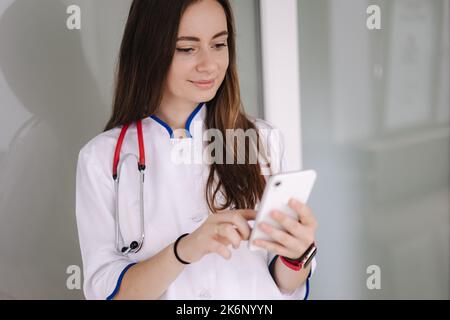 Portrait de youg femme médecin utilisant le téléphone pendant la pause dans clicic Banque D'Images