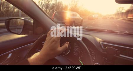 le chauffeur conduit sa voiture dans la ville lors d'une belle journée Banque D'Images