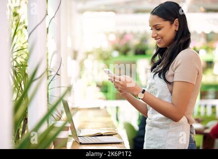 Je pourrais juste dire oui. un fleuriste utilisant son smartphone pour envoyer un message texte. Banque D'Images