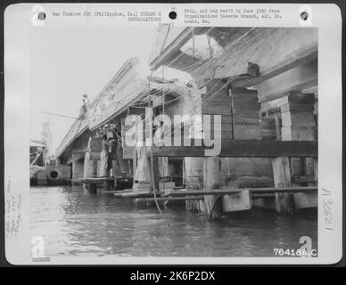 Des hommes du bataillon de l'aviation du 1876th Eng. Travaillent à réparer un pont endommagé par une bombe quelque part dans les îles Philippines. 25 juin 1945. Banque D'Images