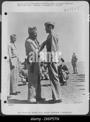 Lieutenant-général Frank M. Andrews, commandant en chef des États-Unis Les forces de l'armée au Moyen-Orient, épinglant le cœur violet sur 1st Lyn Parker, Jr., d'Arkansas City, Ark., pour les blessures reçues lors d'un combat aérien avec des avions ennemis au-dessus de la Méditerranée Banque D'Images