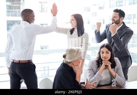J'ai eu beaucoup à fêter. un groupe d'hommes d'affaires qui célèbrent dans un bureau au travail. Banque D'Images
