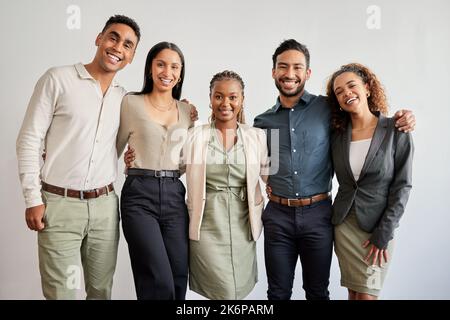 L'équipe qui se tient ensemble, reste ensemble. Portrait d'un groupe de jeunes hommes d'affaires travaillant ensemble dans un bureau moderne. Banque D'Images