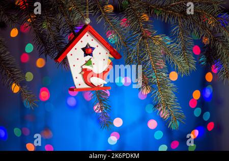 Maison de jouets de Noël avec un oiseau titmouse, fond étincelant et fabuleux avec espace de copie. Fond de Noël pour cartes postales. Décoration de Noël Banque D'Images